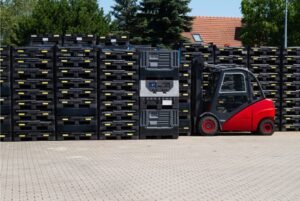Pallets de plástico empilhados em um armazém moderno, prontos para otimizar operações logísticas no atacado e varejo.