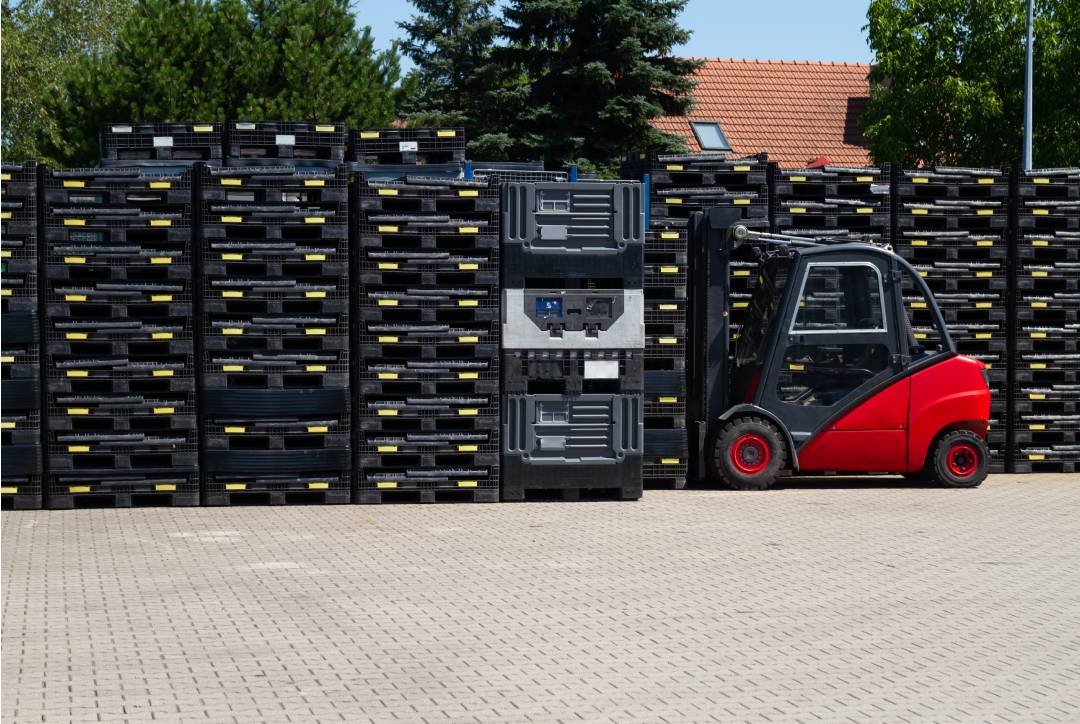 Pallets de plástico empilhados em um armazém moderno, prontos para otimizar operações logísticas no atacado e varejo.